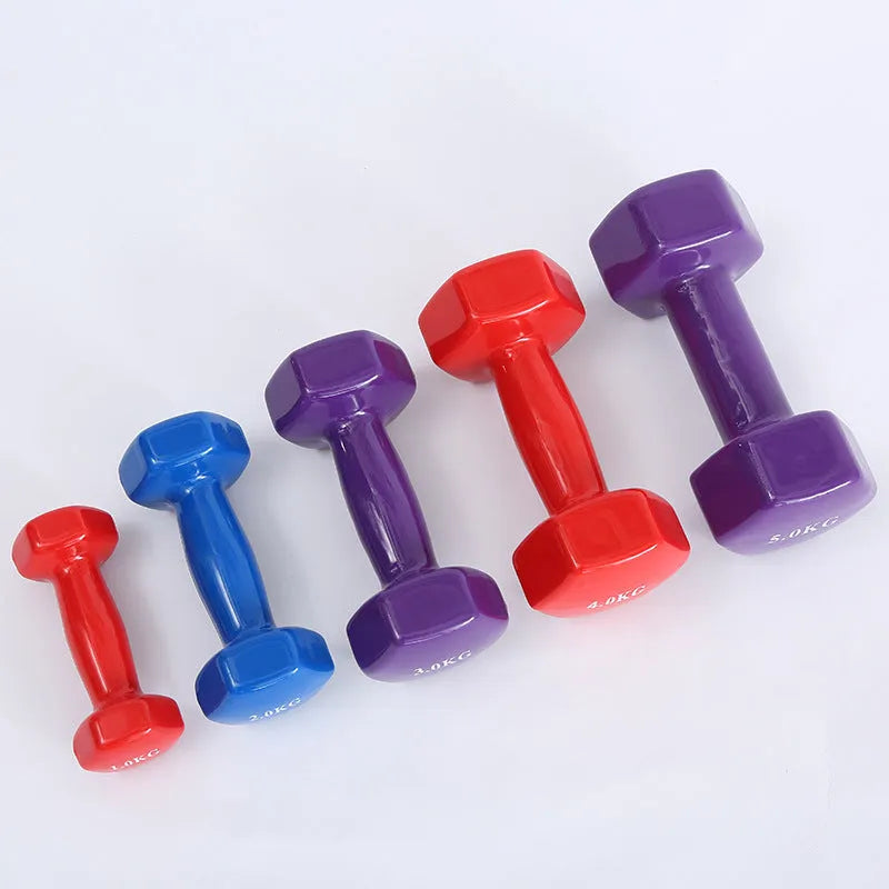 Brightly coloured plastic-coated fitness dumbbells in various weights on a floor.