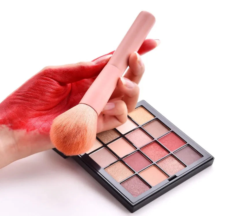 Ten professional makeup brushes with wooden handles in a pink box, including powder, foundation, and double-ended brushes.