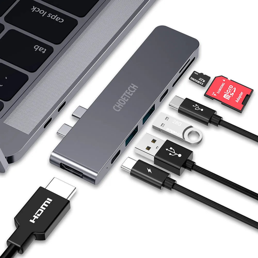 Silver aluminium USB-C hub adapter with SD card slot, HDMI, USB ports, and Thunderbolt 3 connector.