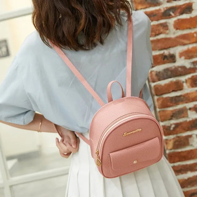 Small black PU shoulder backpack showing front zipper and dimensions