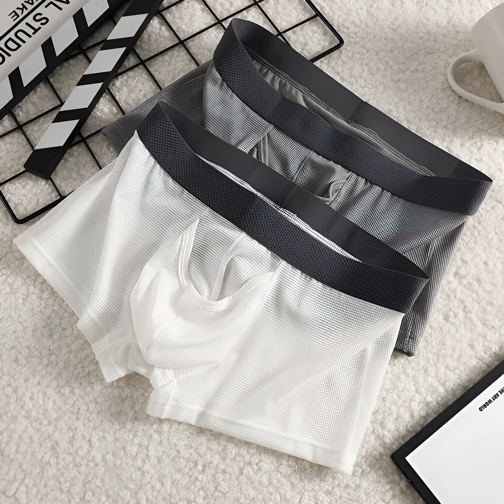 Men's solid colour ice silk boxer shorts showing low waist and breathable mesh fabric.