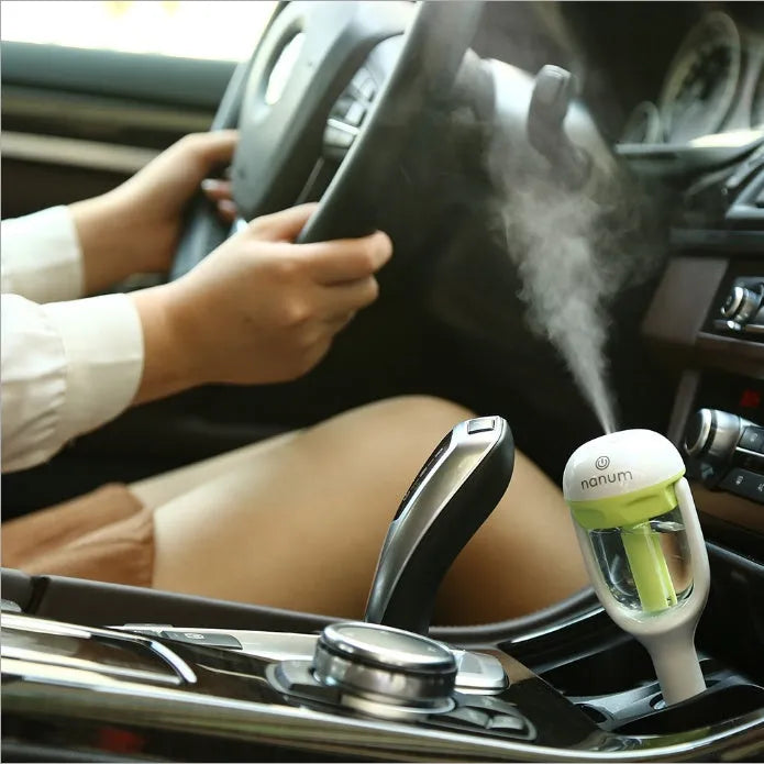 Compact blue portable car humidifier and essential oil diffuser unit on a car dashboard