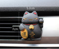 Black cat and white cat resin car vent clip aromatherapy diffuser on a car air conditioning vent.