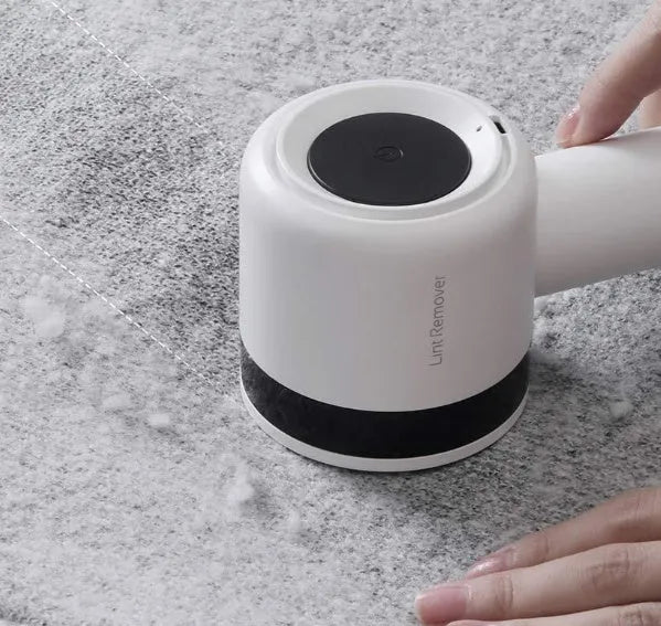 White rechargeable lint remover with three blades, hidden collection container, and ABS build on a plain background