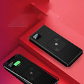 Silver portable power bank with LCD display showing battery percentage, placed next to a smartphone.