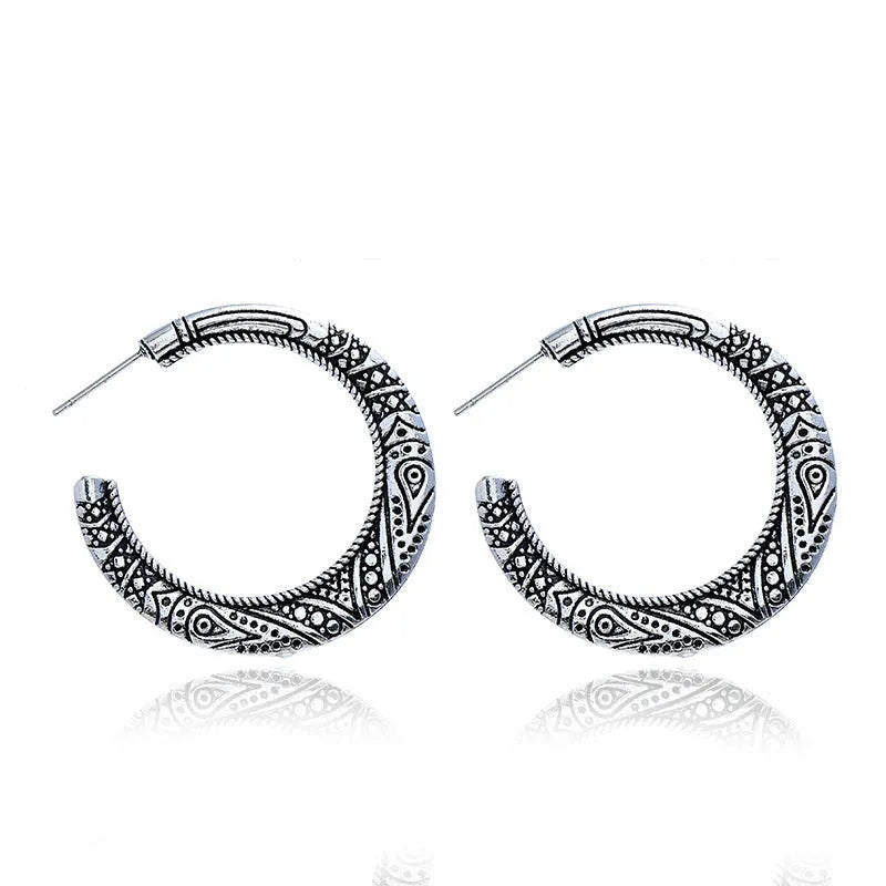 A pair of C-shaped alloy earrings with a vintage engraved pattern, shown in bronze colour.