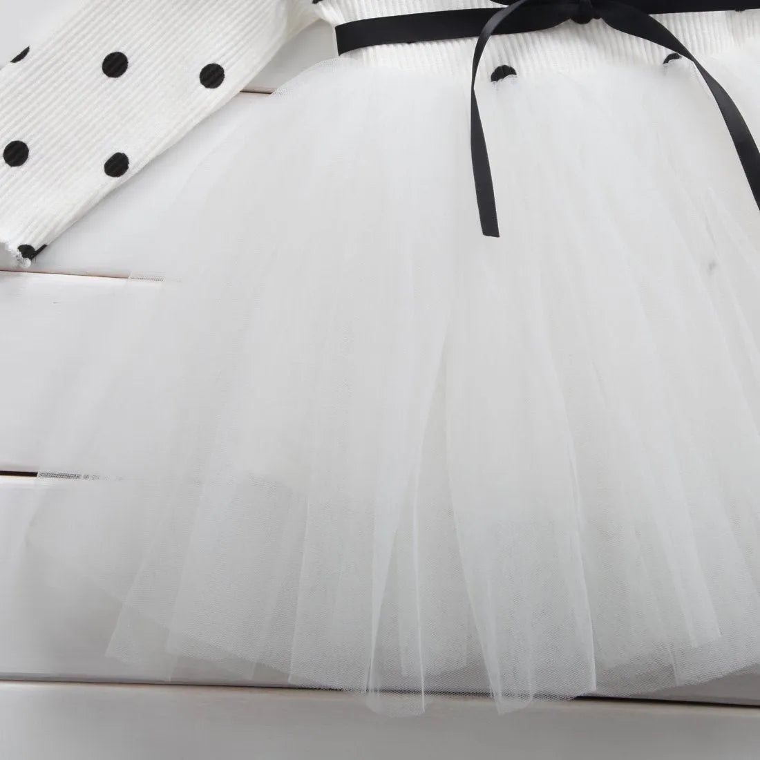 Baby girl in a long sleeve black tutu lace dress for a birthday party.