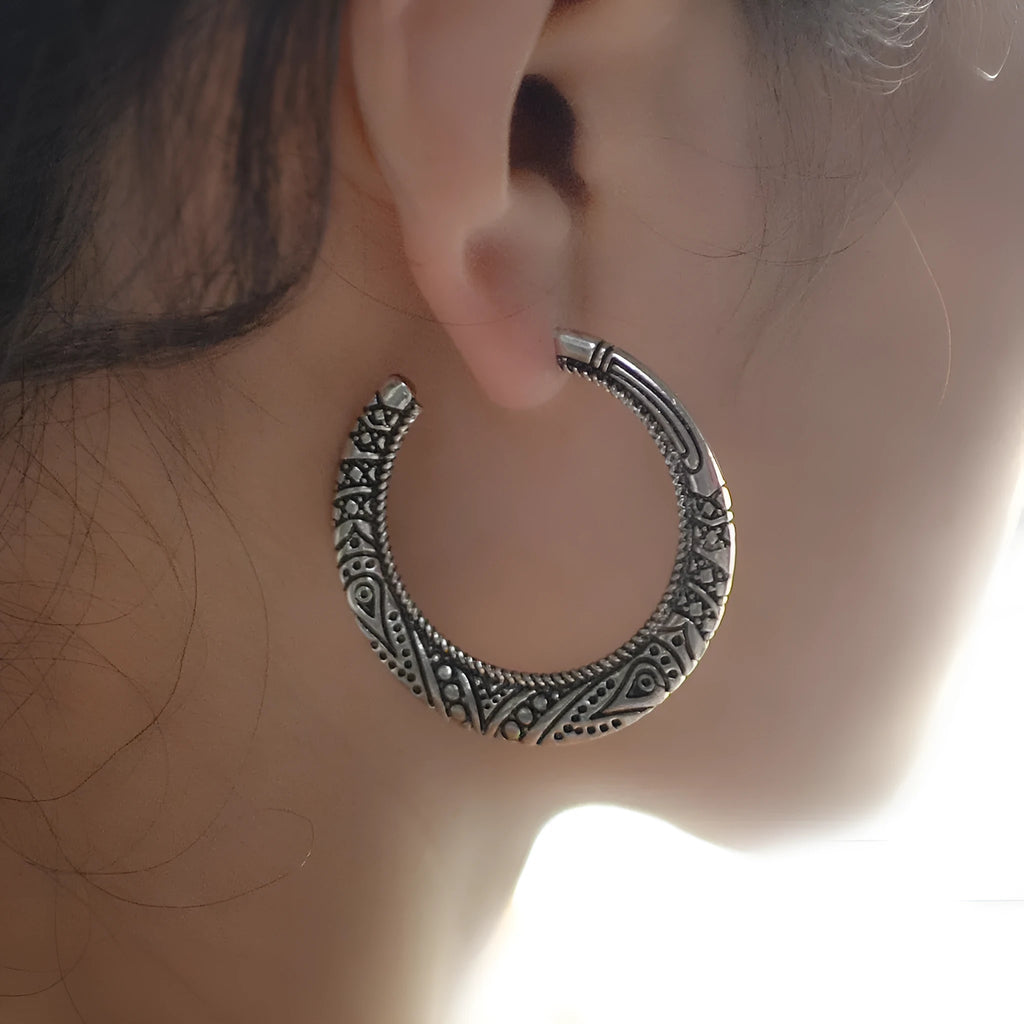 A pair of C-shaped alloy earrings with a vintage engraved pattern, shown in bronze colour.