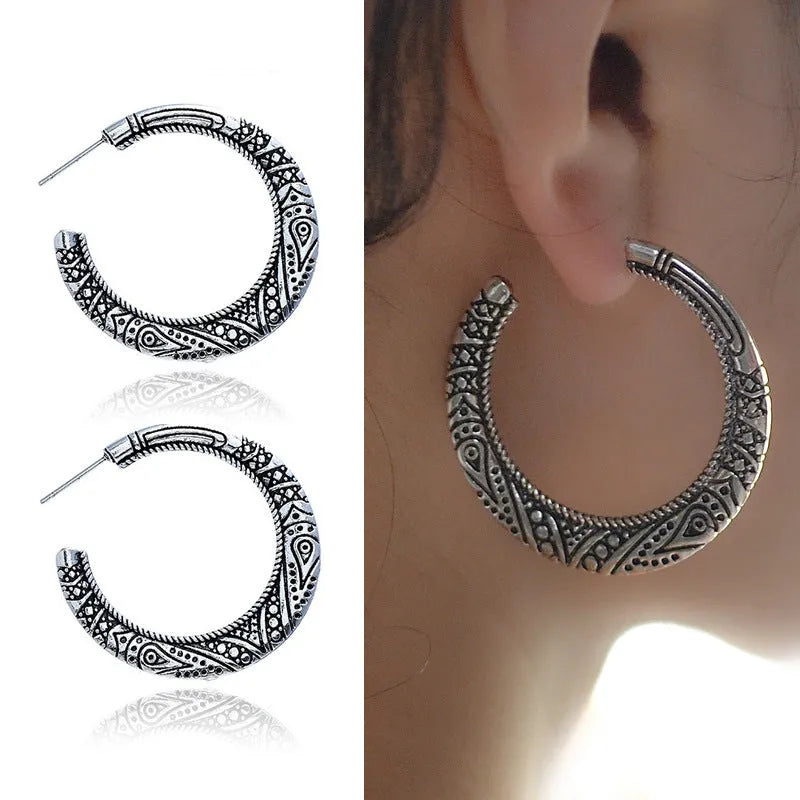 A pair of C-shaped alloy earrings with a vintage engraved pattern, shown in bronze colour.