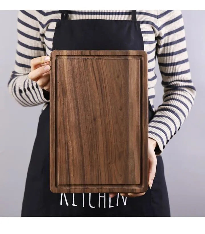Solid black walnut wood cutting board with juice groove and side handle, shown in round and rectangular sizes.
