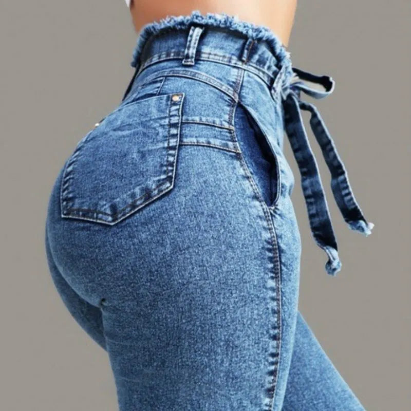 Pair of light blue jeans with a fringed raw hem on a mannequin.