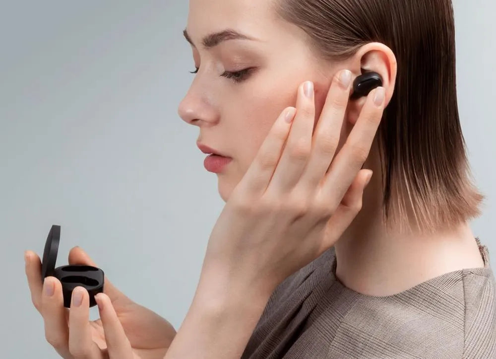 Black Redmi AirDots true wireless earbuds and charging case on a white background.