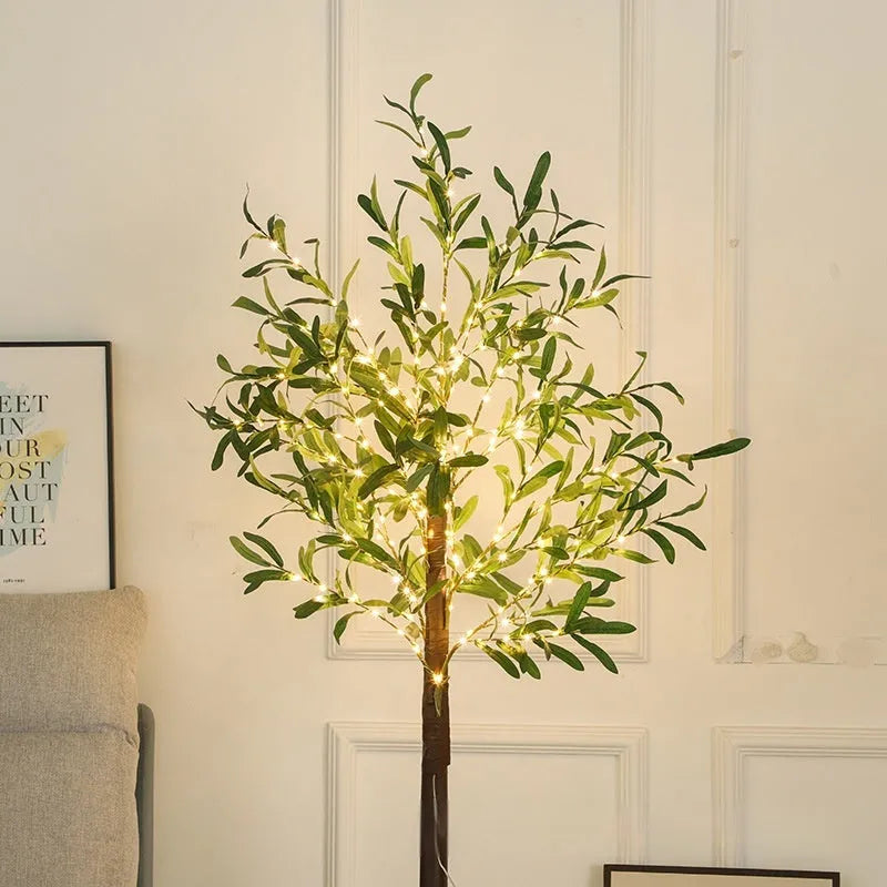 1.8 metre tall artificial olive leaf tree with warm white LED lights illuminated in a garden setting.