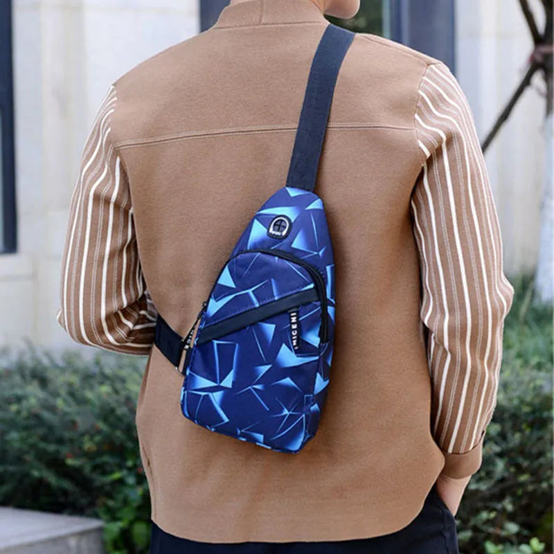 Men's blue print sling chest bag with earphone hole, shown worn crossbody.