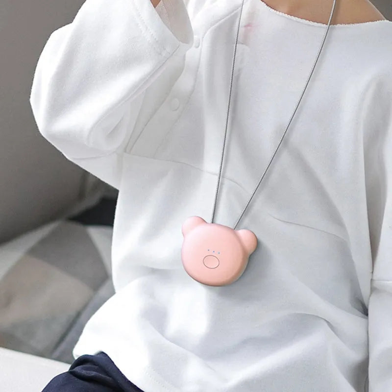 Mini USB air purifier pendant on a necklace, shown in pink colour with charging cable.