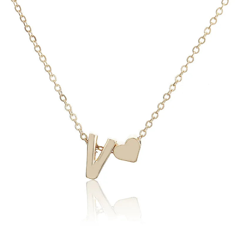 Peach heart shaped alloy pendant with a letter, in gold or silver finish, for necklaces.