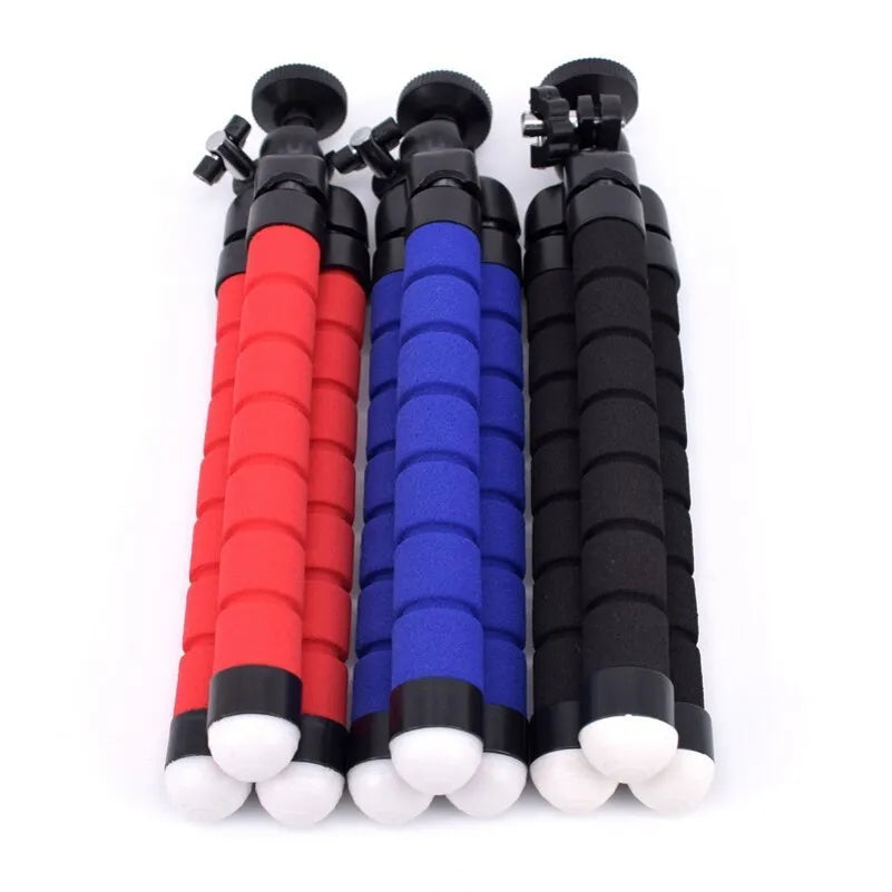 Black flexible octopus-style mini tripod with coiled legs next to a smartphone