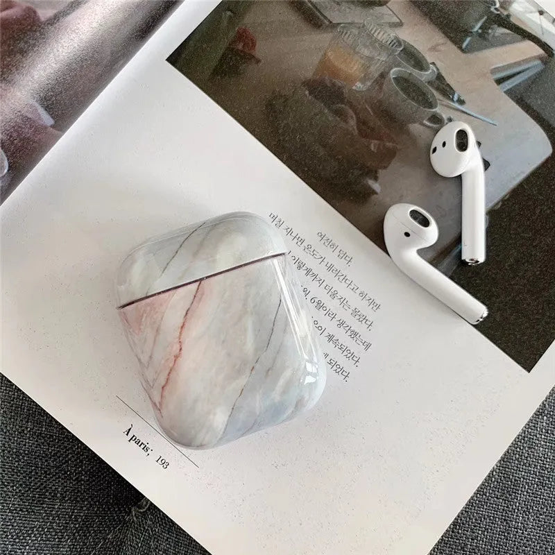 Hard white marble-pattern PC protective case fitted on an AirPods wireless earbud charging box.