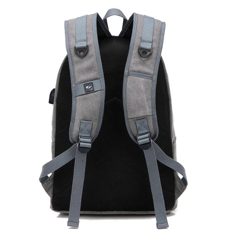 Canvas backpack with USB charging port shown in coffee colour, featuring a laptop compartment and multiple pockets.