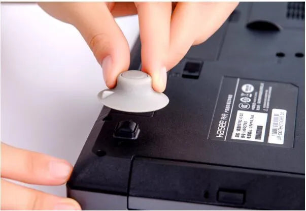 Set of four grey plastic laptop cooling pads, two large and two small, on a flat surface.