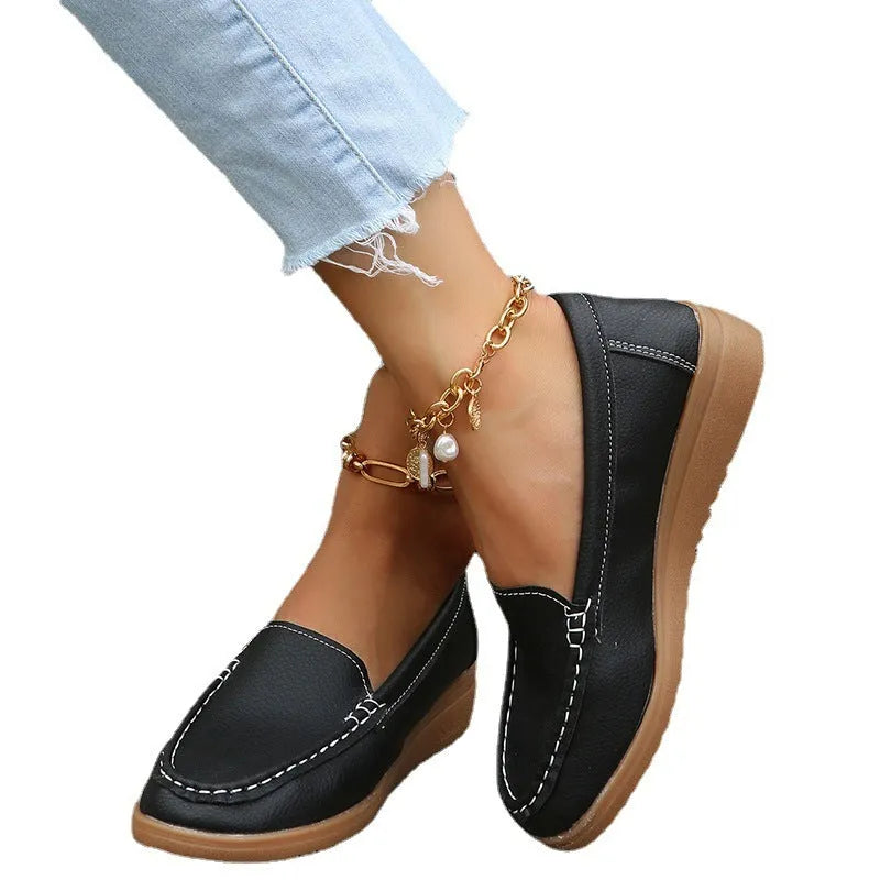 Women's white PU leather slip-on loafer flats with round toe and rubber sole on a plain background.