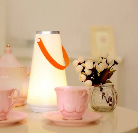 White rechargeable LED lantern night light with USB cable on a table
