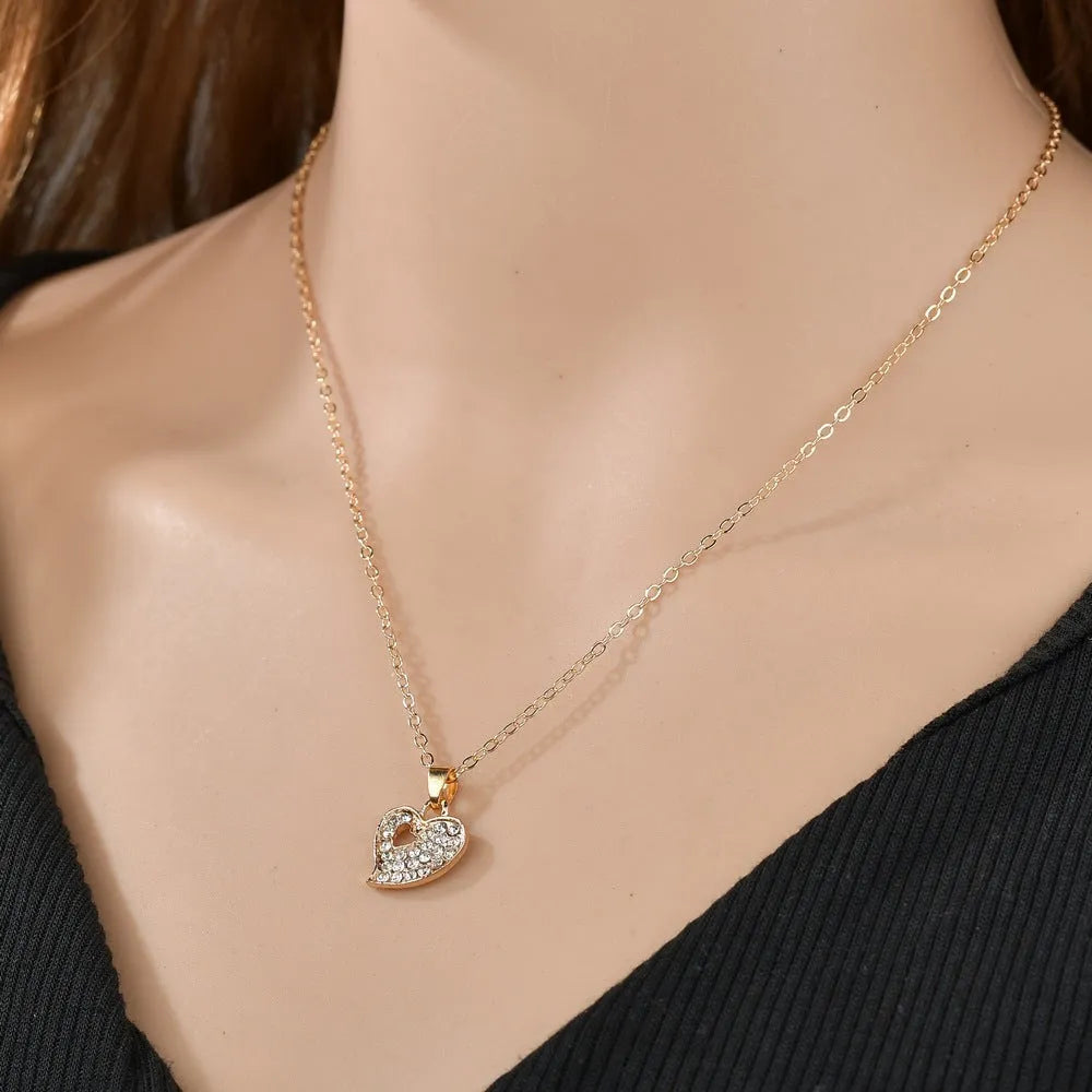Gold alloy jewellery set with love, water drop and bell charms including earrings, pendant and bracelet