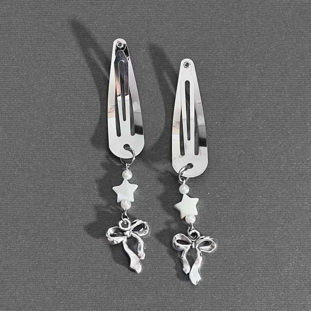 Silver metal alloy star bow hair clip with electroplated finish on neutral background