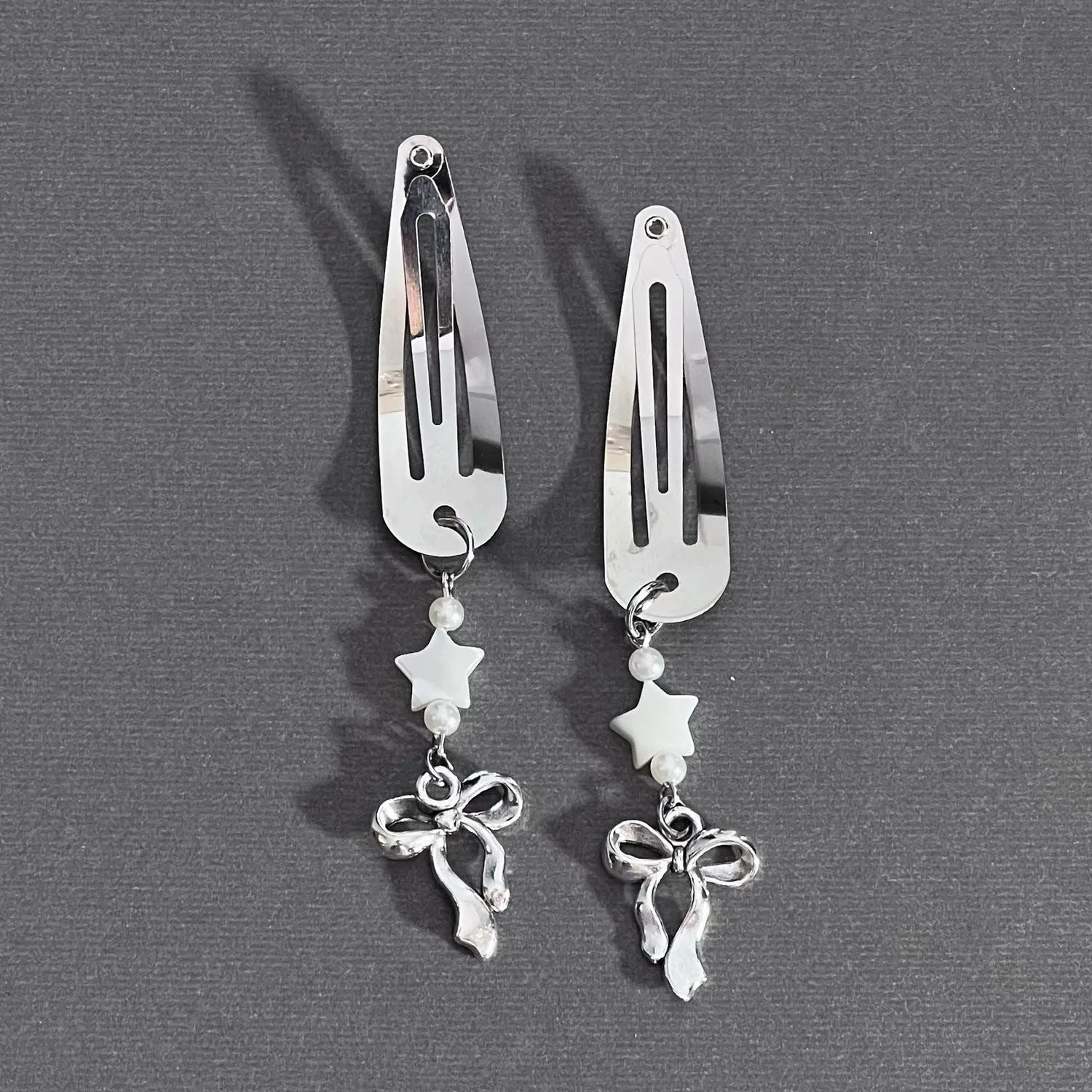 Silver metal alloy star bow hair clip with electroplated finish on neutral background