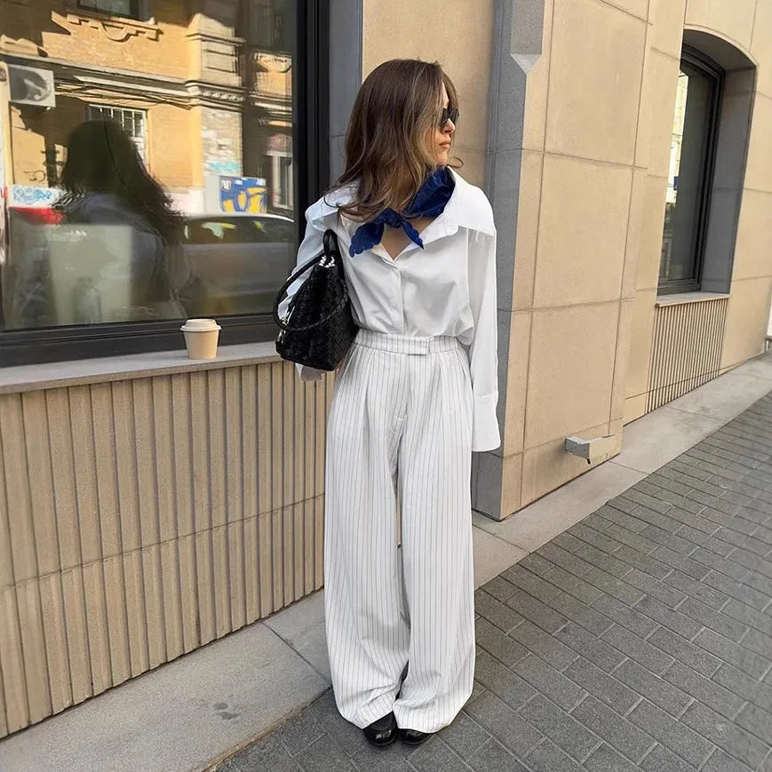 White women's wide-leg trousers with a stripe detail and zip fastening, laid flat.