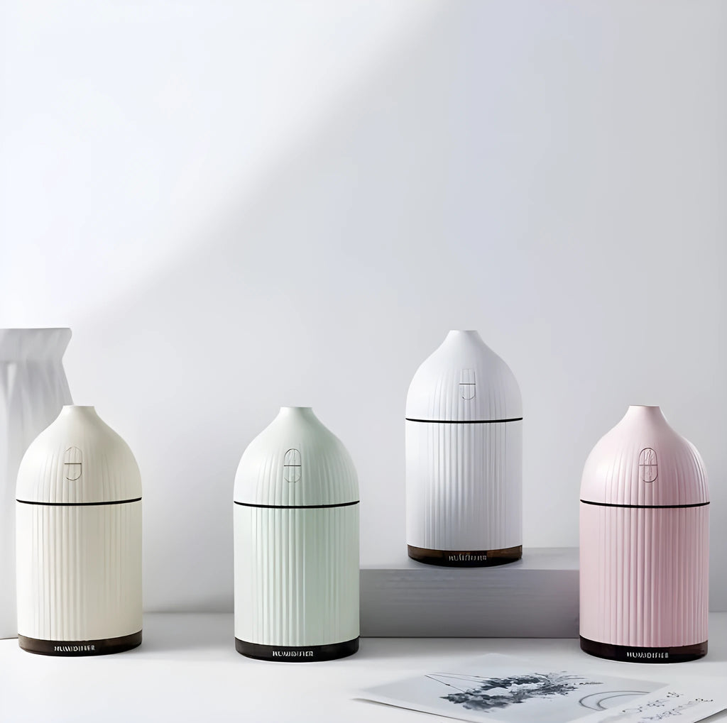 White square aromatherapy diffuser and humidifier with LED light on a wooden desk.