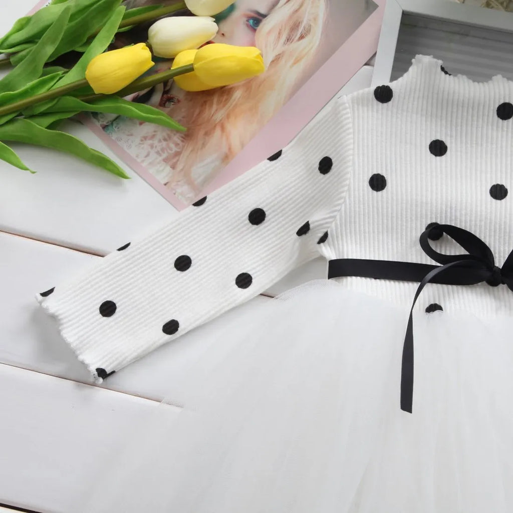 Baby girl in a long sleeve black tutu lace dress for a birthday party.