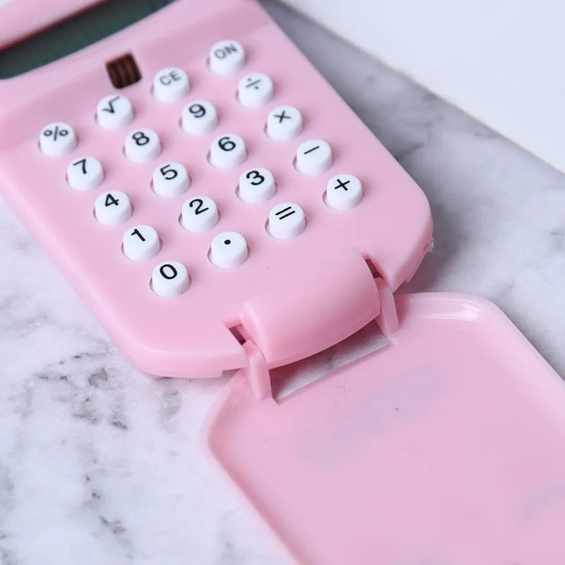 Creative cookie-shaped cute mini plastic calculator in black with key ring on a desk