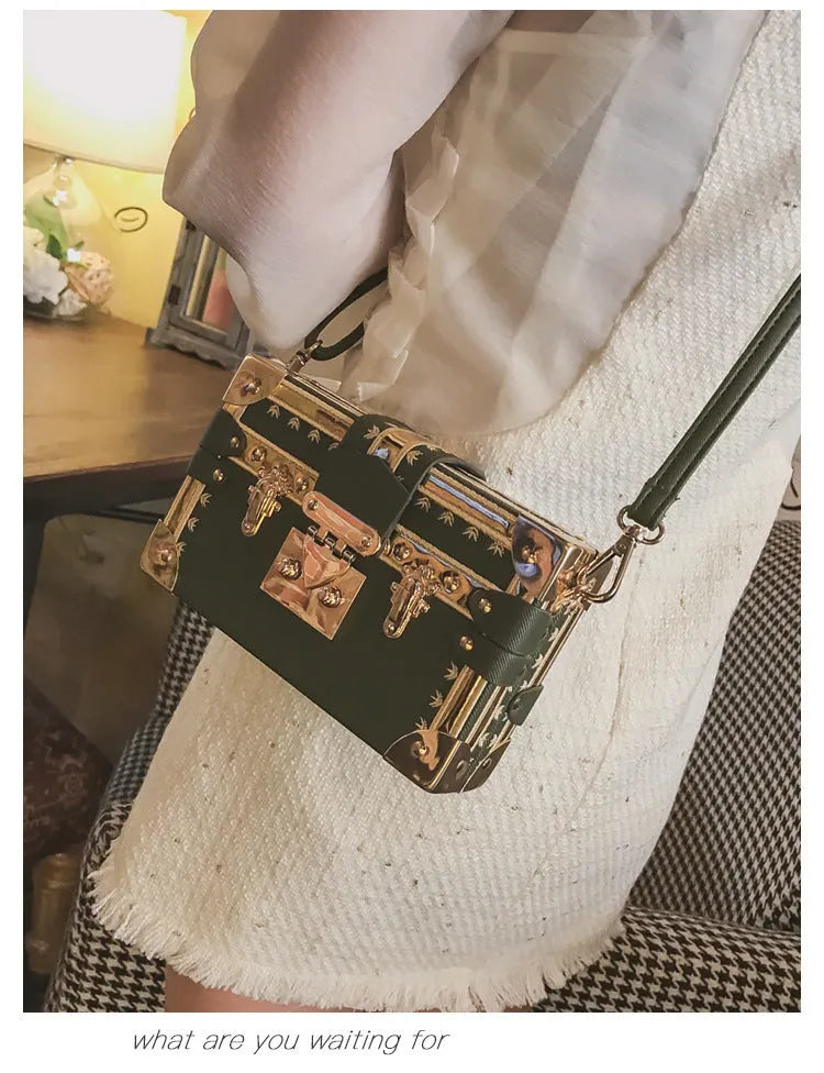 Women's hard frame shoulder bag in black or green with single adjustable strap and flap closure