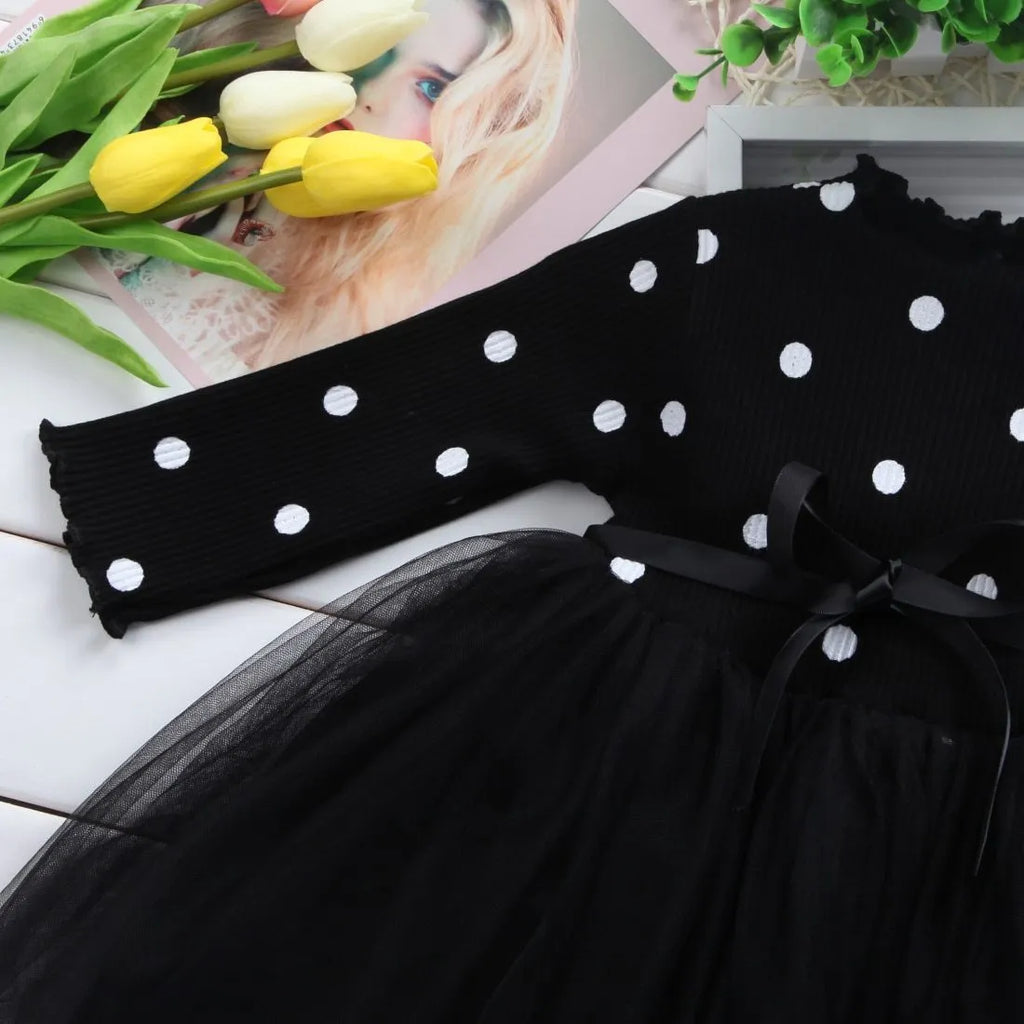 Baby girl in a long sleeve black tutu lace dress for a birthday party.