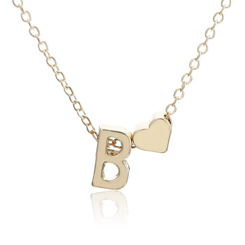 Peach heart shaped alloy pendant with a letter, in gold or silver finish, for necklaces.