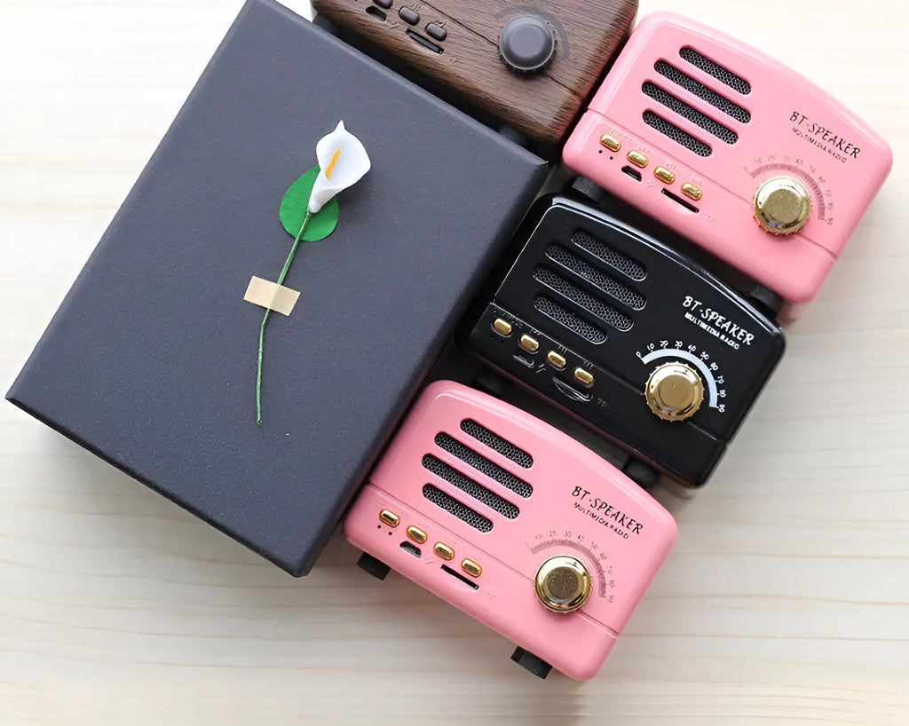 Vintage wood finish bluetooth speaker in pink, black, and wood grain colour options showing compact design