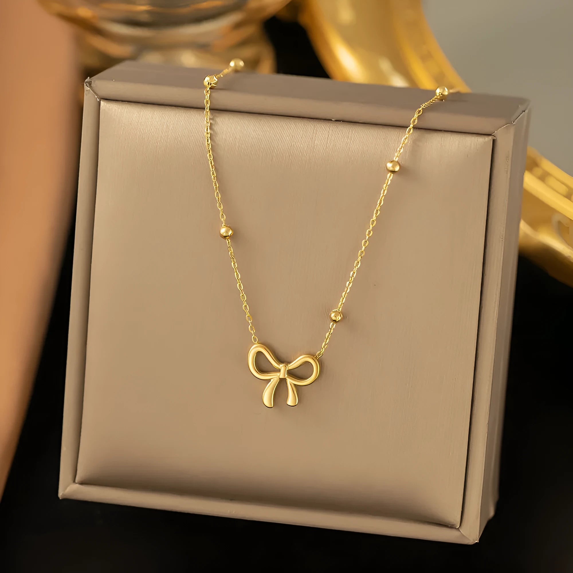 Gold bow necklace on titanium steel cross chain with adjustable 41-50cm length