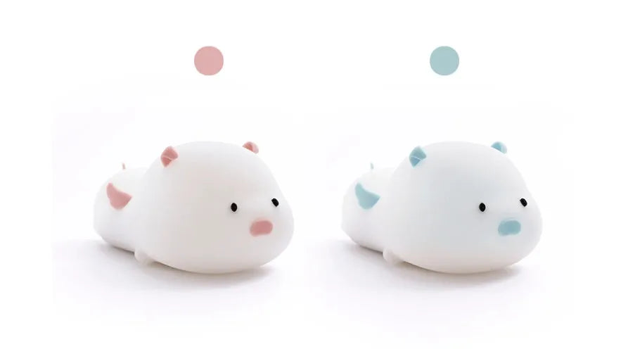 Cute pig silicone night light in Pink with sleeping face design on a wooden table