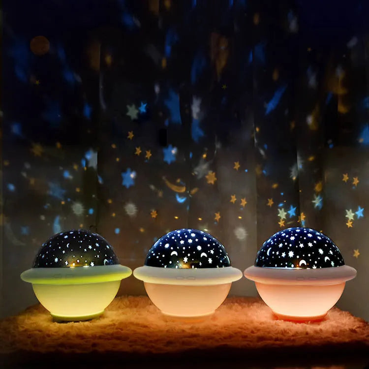 Green UFO-shaped plastic night light projecting starry sky pattern on a wall