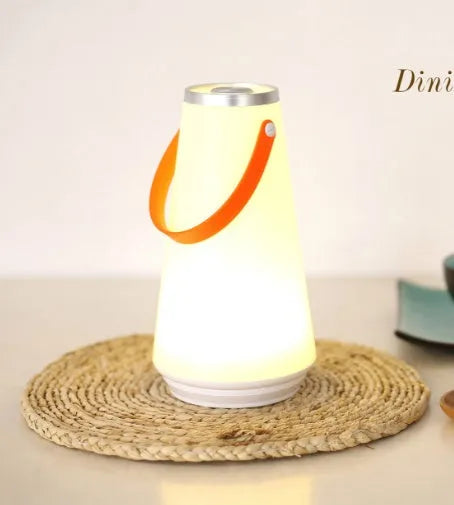 White rechargeable LED lantern night light with USB cable on a table