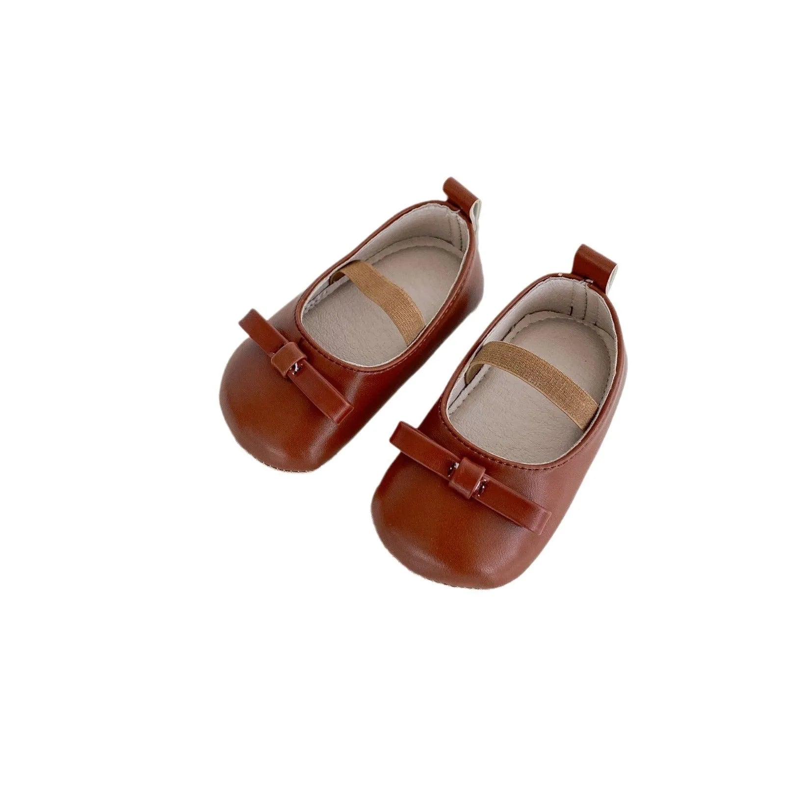 Baby shoes in white with bow detail, non-slip rubber sole, and elastic band fastening