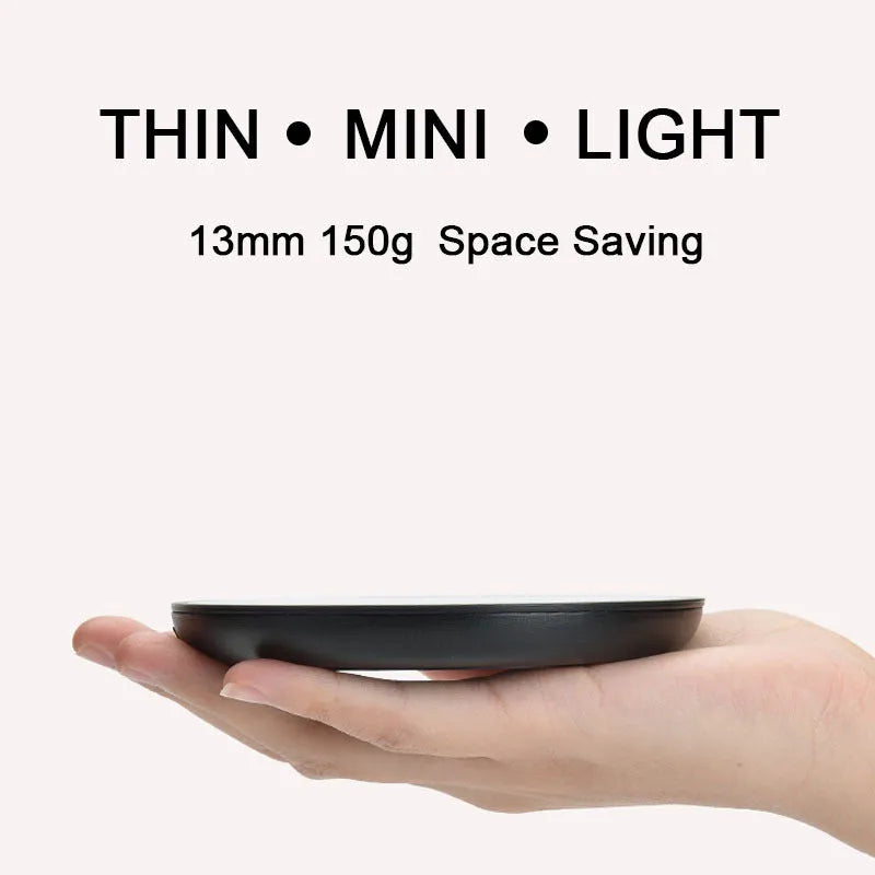 Black coffee mug warmer with temperature control dial on desk