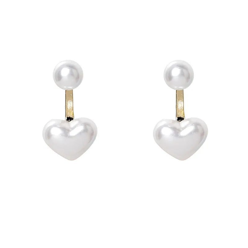 Close-up of women's heart-shaped alloy stud earrings with pearl-like appearance and electroplated finish.