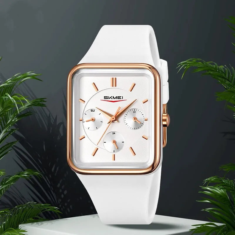 Square analogue silicone watch for women in white rose gold colour on a wrist, showing slim profile.