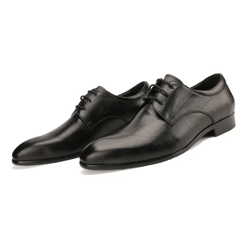 Men's black leather derby shoes with a pointed toe and rubber sole on a neutral background.
