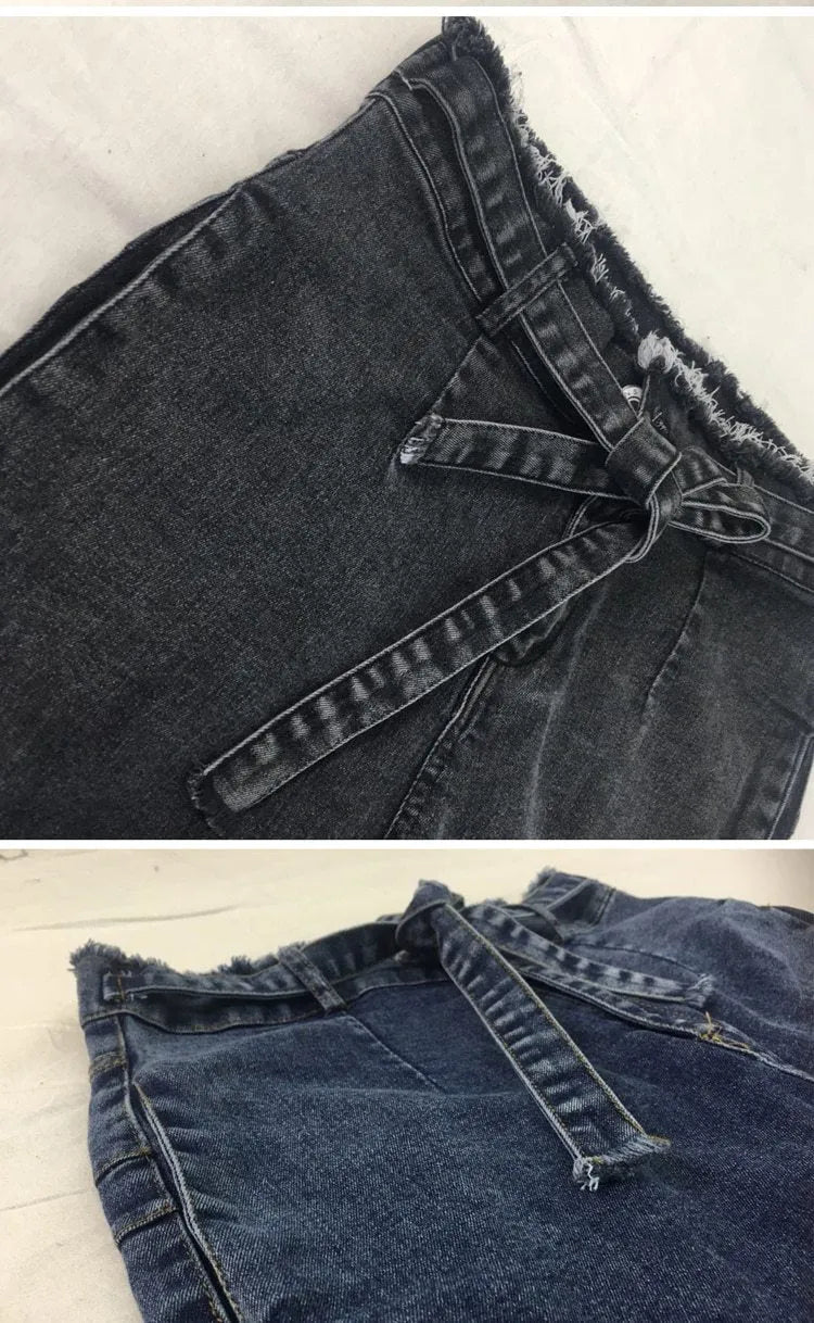 Pair of light blue jeans with a fringed raw hem on a mannequin.