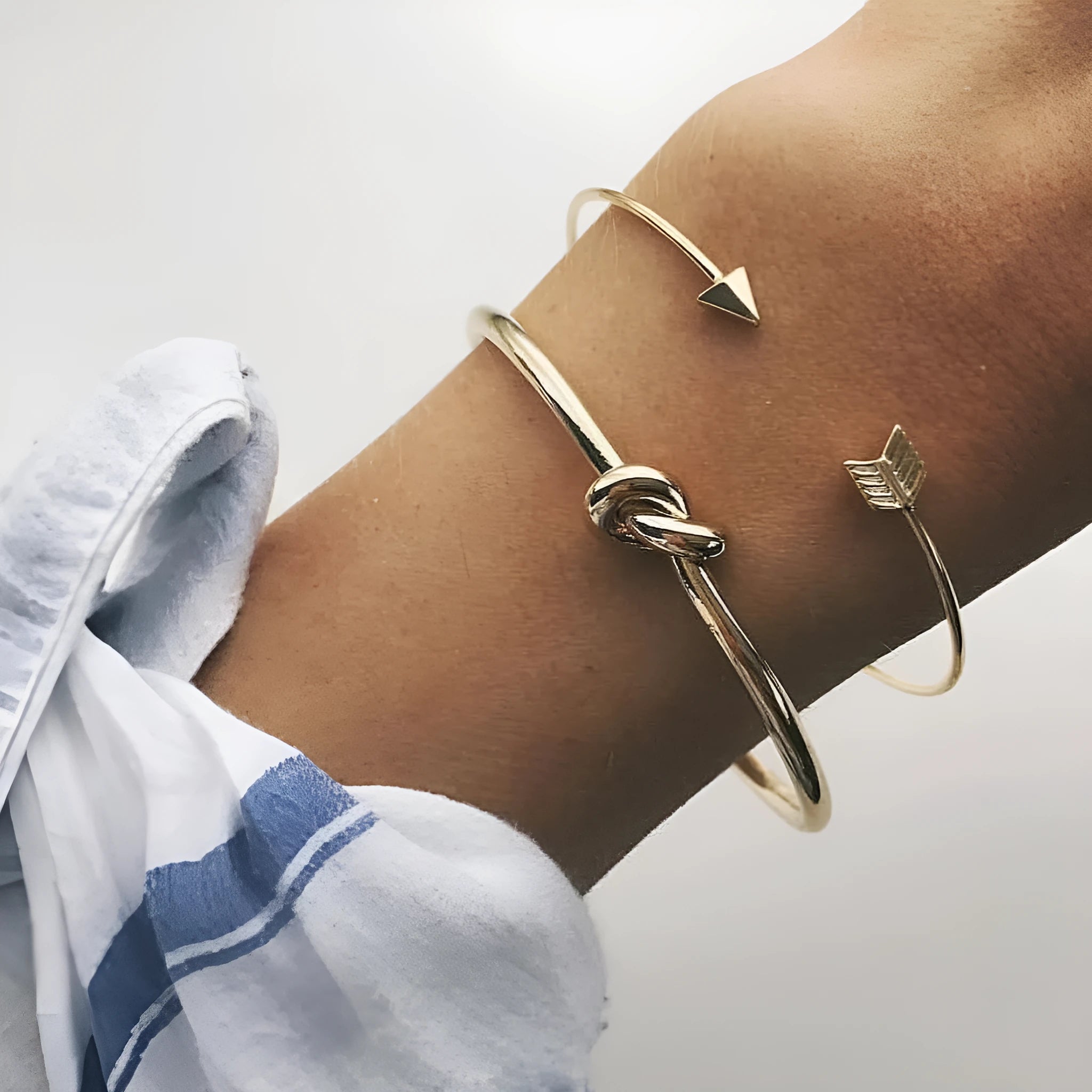 Gold electroplated alloy women's cuff bracelet with vintage arrow and knot design.