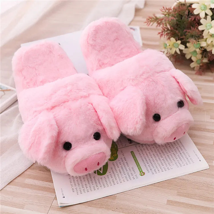 Pink pig-shaped plush floor slippers for adults on a white background.
