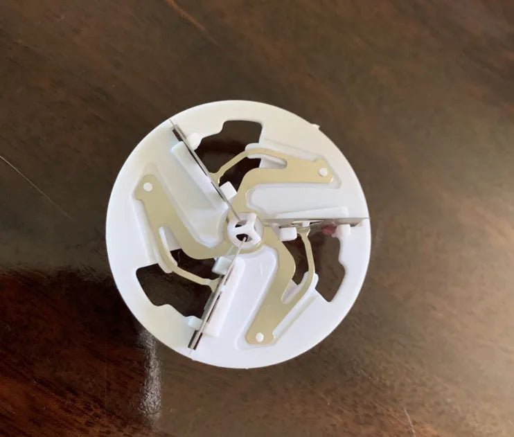 White rechargeable lint remover with three blades, hidden collection container, and ABS build on a plain background